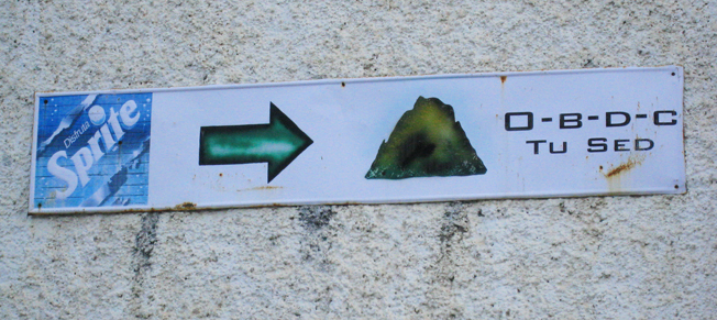 Fig. 21 Señal que indica la ubicación de un lugar, es este caso patrocinado por el refresco Sprite, que tiene en ese orden: el logotipo, una flecha y una imagen, que aunque a simple vista no se reconozca, se trata de la dirección para subir a la Peña de Bernal, en Querétaro. Por ello, es importante destacar que el contexto hace que sea más sencillo de interpretar el mensaje. (archivo de la autora).